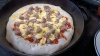 The in-progress breakfast pizza in the cast-iron pan. It has two of three toppings - specifically, egg and sausage.